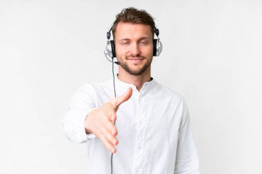 Tele pazarlamacı beyaz kulaklıkla çalışan beyaz bir adam iyi bir anlaşma için el sıkışıyor.