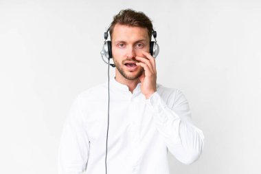Tele pazarlamacı beyaz kulaklıkla çalışan beyaz bir adam. Şaşırmış ve şok olmuş bir yüz ifadesi var.