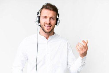 Tele pazarlamacı, beyaz arka plan üzerinde çalışan beyaz kulaklıklı beyaz bir adam gitar hareketi yapıyor.