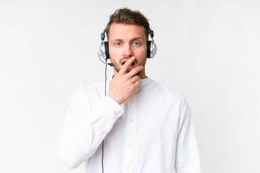 Tele pazarlamacı, beyaz arka planda kulaklıkla çalışan beyaz bir adam sağa bakarken şaşırmış ve şok olmuştu.