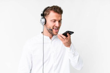 Tele pazarlamacı beyaz arka planda kulaklıkla çalışan beyaz bir adam cep telefonuyla sohbet ediyor.