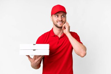 Pizza teslimatçısı üniformalı adam izole edilmiş beyaz arka planda pizza kutuları alıyor.