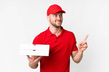 Pizza teslimatçısı üniformalı adam izole edilmiş beyaz arka planda pizza kutuları alıyor. Harika bir fikir.