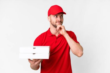 Pizza teslimatçısı üniformalı adam izole edilmiş beyaz arka planda pizza kutuları alıyor ve...