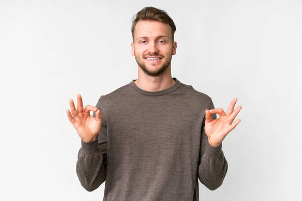 stock image Young handsome caucasian man over isolated white background showing ok sign with two hands