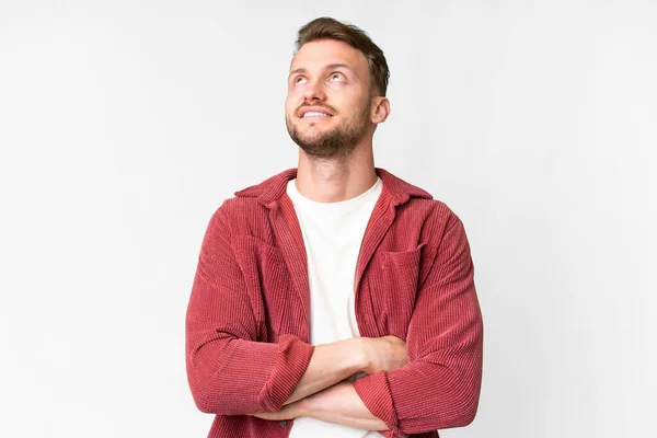 stock image Young handsome caucasian man over isolated white background looking up while smiling