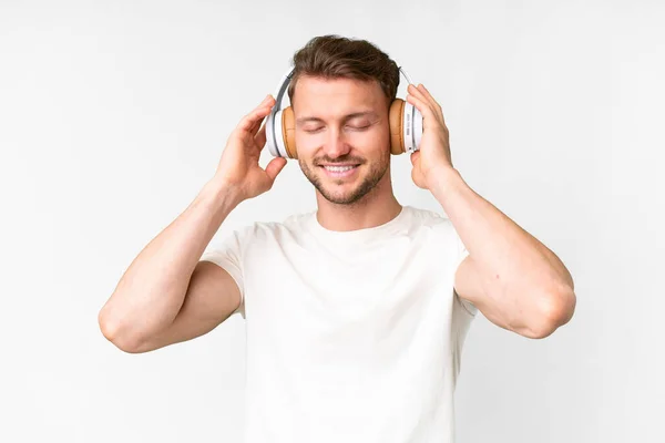 Νεαρός Όμορφος Καυκάσιος Πάνω Από Απομονωμένο Λευκό Φόντο Ακούγοντας Μουσική — Φωτογραφία Αρχείου