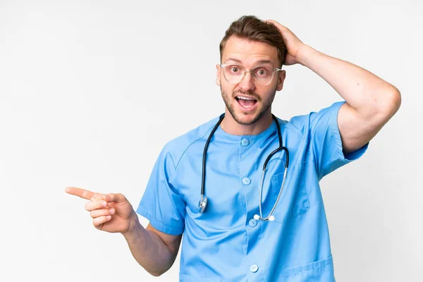 Young Nurse Man Isolated White Background Surprised Pointing Finger Side — Stock Photo, Image