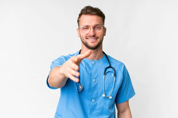 Junger Krankenpfleger Vor Isoliertem Weißen Hintergrund Beim Händeschütteln Für Ein — Stockfoto
