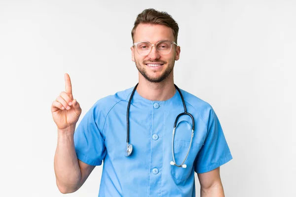 Молода Медсестра Над Ізольованим Білим Тлом Показує Піднімає Палець Знак — стокове фото