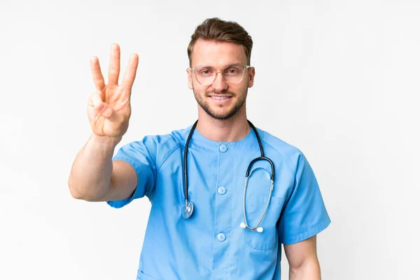 年轻的护士在孤独的白色背景上快乐地数着三根手指 — 图库照片