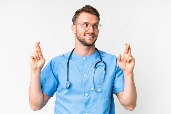 Jovem Enfermeira Homem Sobre Isolado Fundo Branco Com Dedos Cruzando — Fotografia de Stock