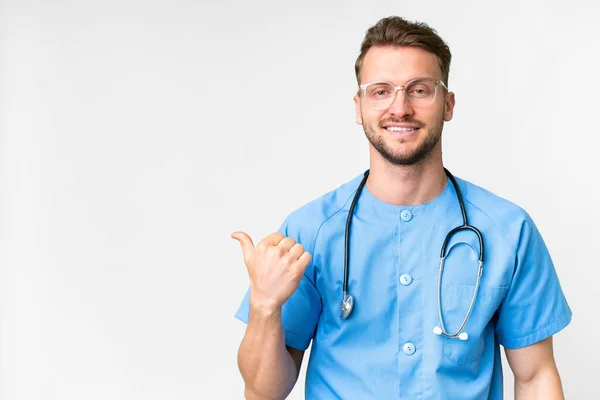 Junge Krankenschwester Mann Über Isolierten Weißen Hintergrund Zeigt Auf Die — Stockfoto