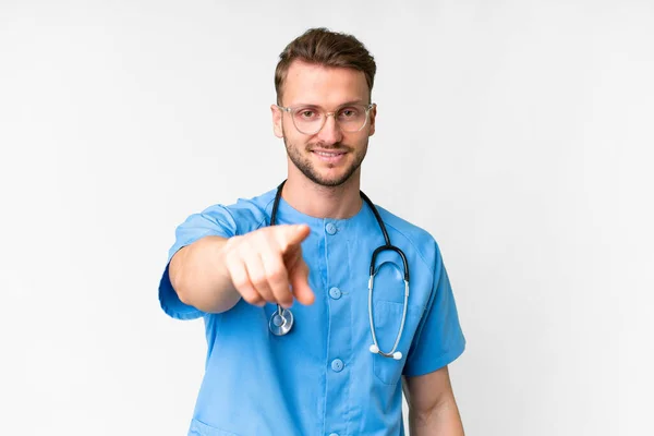 Junger Krankenpfleger Vor Isoliertem Weißen Hintergrund Zeigt Mit Selbstbewusstem Gesichtsausdruck — Stockfoto