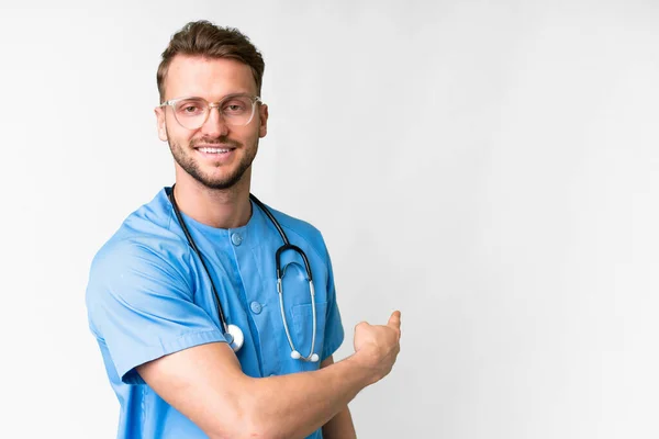 Junge Krankenschwester Mann Über Isolierten Weißen Hintergrund Zeigt Zurück — Stockfoto