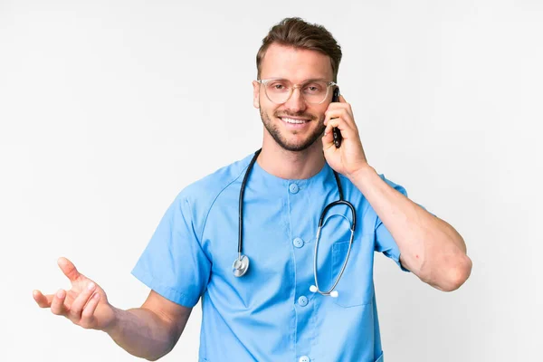 孤立した白い背景の上に若い看護師の男誰かと携帯電話との会話を保つ — ストック写真