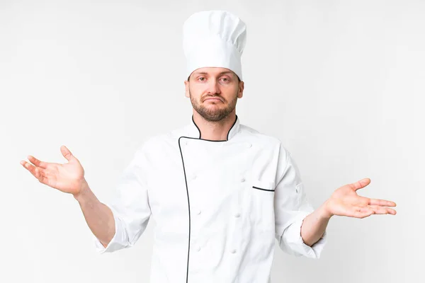 Jonge Kaukasische Chef Kok Geïsoleerde Witte Achtergrond Met Twijfels Terwijl — Stockfoto