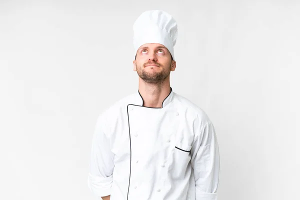 Jovem Chef Caucasiano Sobre Fundo Branco Isolado Olhando Para Cima — Fotografia de Stock
