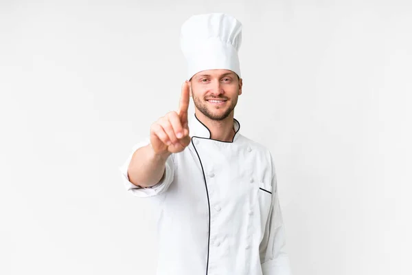 Junge Kaukasische Koch Über Isolierten Weißen Hintergrund Zeigt Und Hebt — Stockfoto