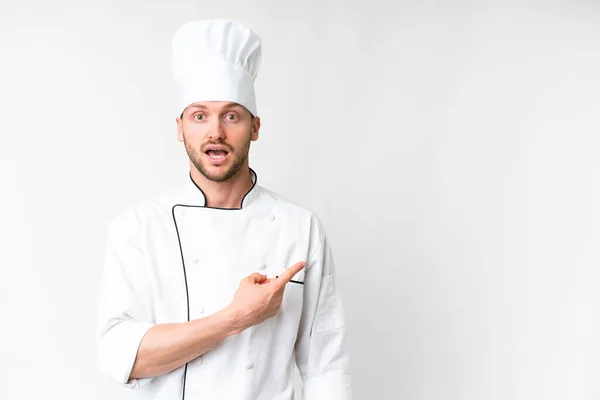 Young Caucasian Chef Isolated White Background Surprised Pointing Side — Fotografia de Stock