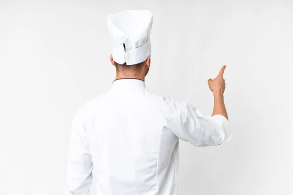 Joven Chef Caucásico Sobre Fondo Blanco Aislado Apuntando Hacia Atrás —  Fotos de Stock