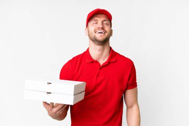 Pizza teslimatçısı üniformalı adam izole edilmiş beyaz arka planda pizza kutuları alıyor ve gülüyor.