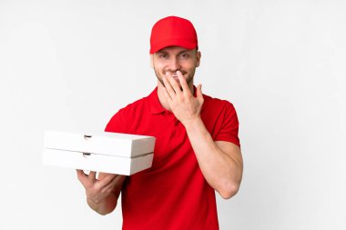 Pizza delivery man with work uniform picking up pizza boxes over isolated white background happy and smiling covering mouth with hand