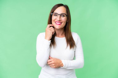 Orta yaşlı kadın izole edilmiş krom anahtar arka planda gülüyor.