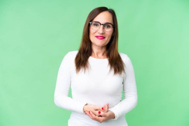 Orta yaşlı kadın izole edilmiş krom anahtar arka planda gülüyor.