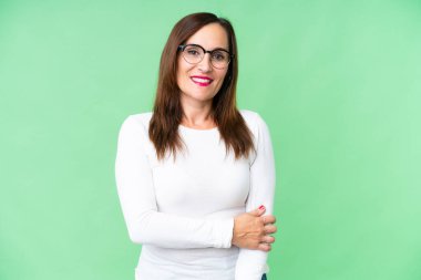 Orta yaşlı kadın izole edilmiş krom anahtar arka planda gülüyor.