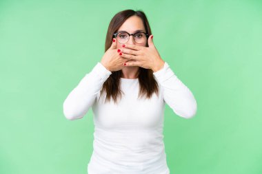 Orta yaşlı kadın izole edilmiş krom anahtar arka planda ağzı elleriyle kapatıyor.