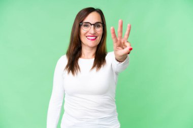 Orta yaşlı kadın izole edilmiş krom anahtar geçmişi mutlu ve parmaklarıyla üçe kadar sayıyor.