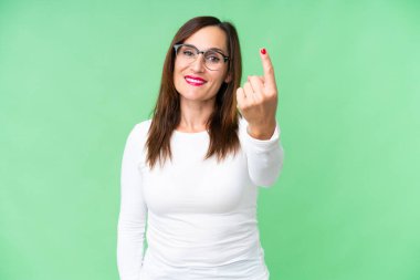 Orta yaşlı bir kadın izole edilmiş krom anahtar geçmişi olan bir jest yapıyor.