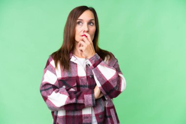 Orta yaşlı kadın izole edilmiş krom anahtar arka planda kuşkuları ve kafa karıştırıcı yüz ifadesi olan