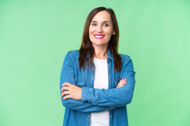 Middle age woman over isolated chroma key background keeping the arms crossed in frontal position