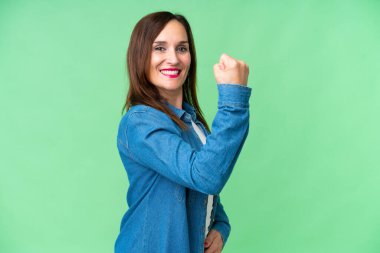 Middle age woman over isolated chroma key background doing strong gesture