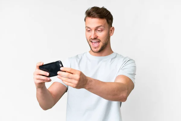 年轻英俊的高加索男子与孤独的白人背景玩手机 — 图库照片
