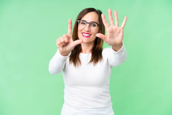 stock image Middle age woman over isolated chroma key background counting seven with fingers