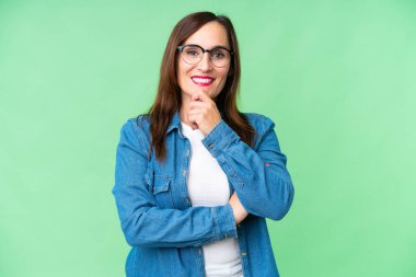Gözlüklü ve gülümseyen orta yaşlı bir kadın.