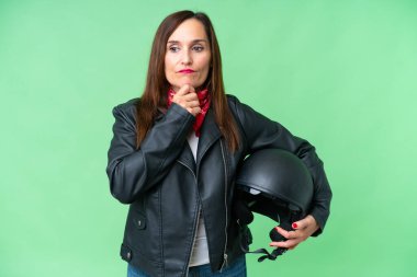 İzole edilmiş krom anahtar geçmişi olan, motosiklet kasklı, orta yaşlı beyaz bir kadın. Şüpheleri ve düşünceleri var.