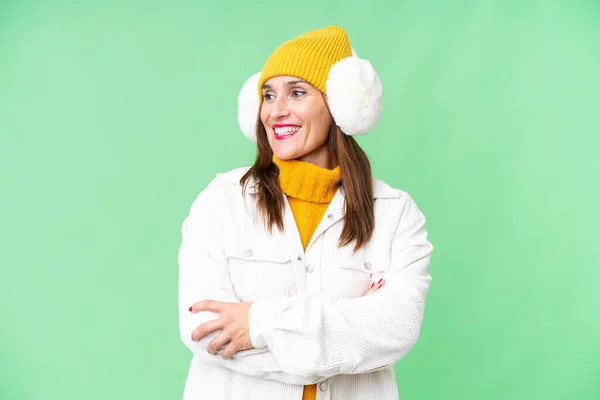 中年妇女披着冬衣 披着孤零零的彩色背景 快乐而微笑 — 图库照片