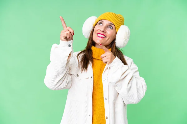 中年妇女穿着冬衣 罩在孤立的彩色关键背景上 用食指指尖着一个很好的主意 — 图库照片