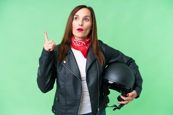 中年妇女头戴摩托车头盔 头戴独立的彩色关键背景 认为这是一个指指点点的想法 — 图库照片