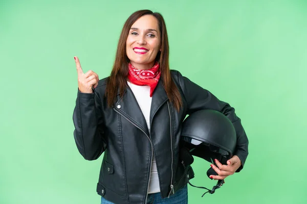 中年Caucasian女性とともにオートバイヘルメット以上隔離されたクロマキー背景ショーと持ち上げ指で最高のサイン — ストック写真
