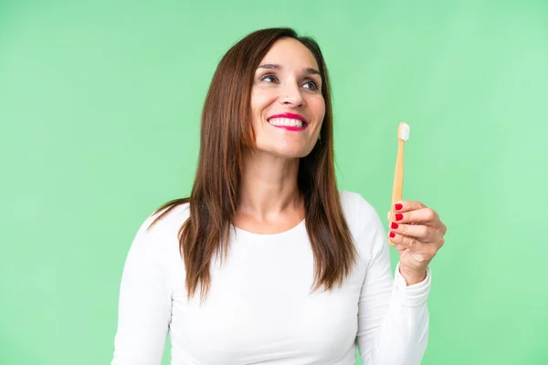 Женщина Средних Лет Чистила Зубы Над Изолированным Хрома Ключевым Фоном — стоковое фото