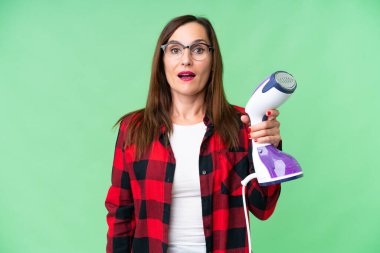 Dikey buharlı ütü tutan genç bir kadın.