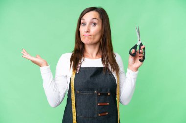 Seamstress woman over isolated chroma key background having doubts while raising hands