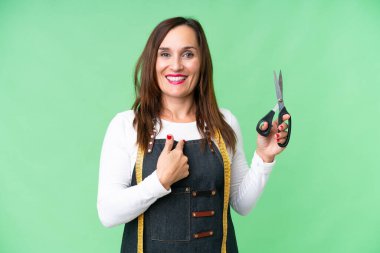 Terzi kadın izole edilmiş krom anahtar arka planda ve şaşırtıcı yüz ifadesi var.