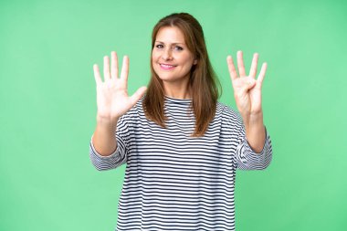 Orta yaşlı bir kadın izole edilmiş arka planda dokuz parmaklı sayıyor.