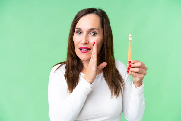 中年女性ブラッシング歯上隔離されたクロマキー背景ささやき何か — ストック写真